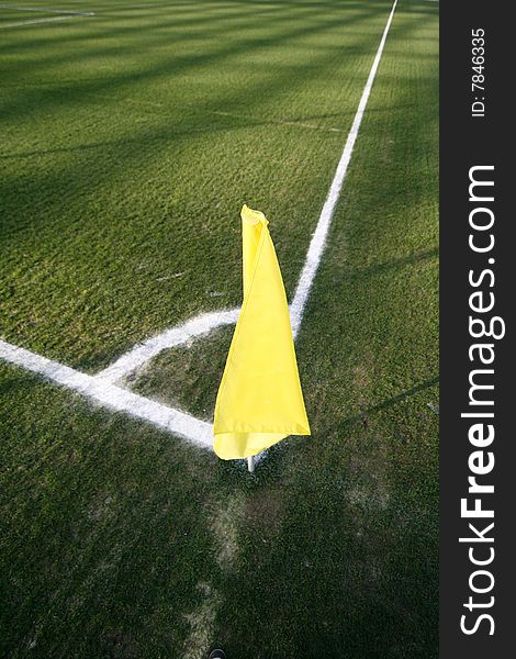 A yellow flag on a football field in a stadium
