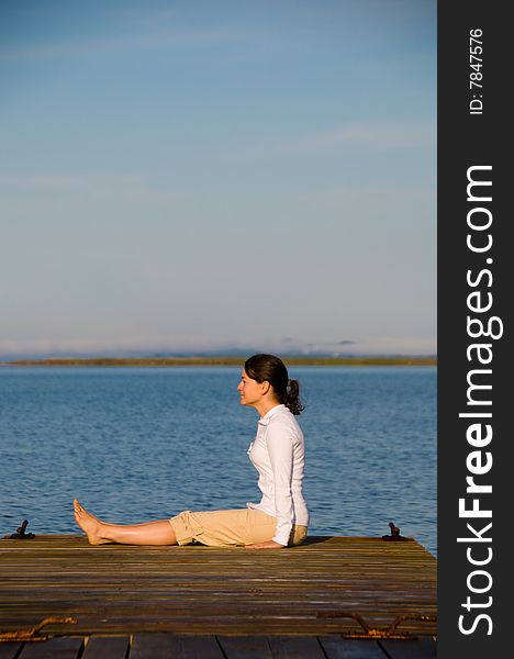 Yoga Woman on a dock by the ocean