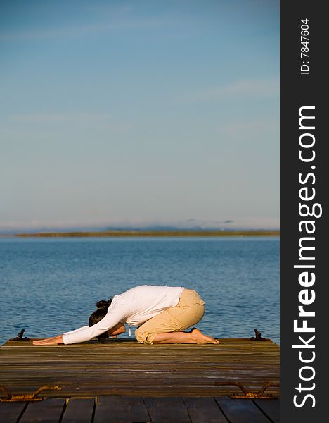 Yoga Woman on a dock by the ocean