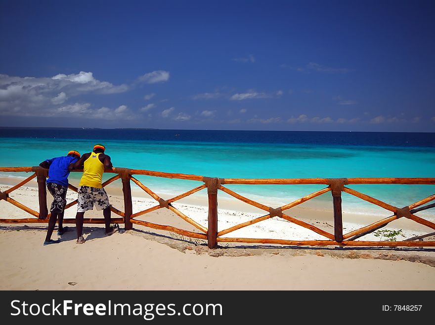 leaning on a wooden fence at the beach, zanzibar africa. leaning on a wooden fence at the beach, zanzibar africa