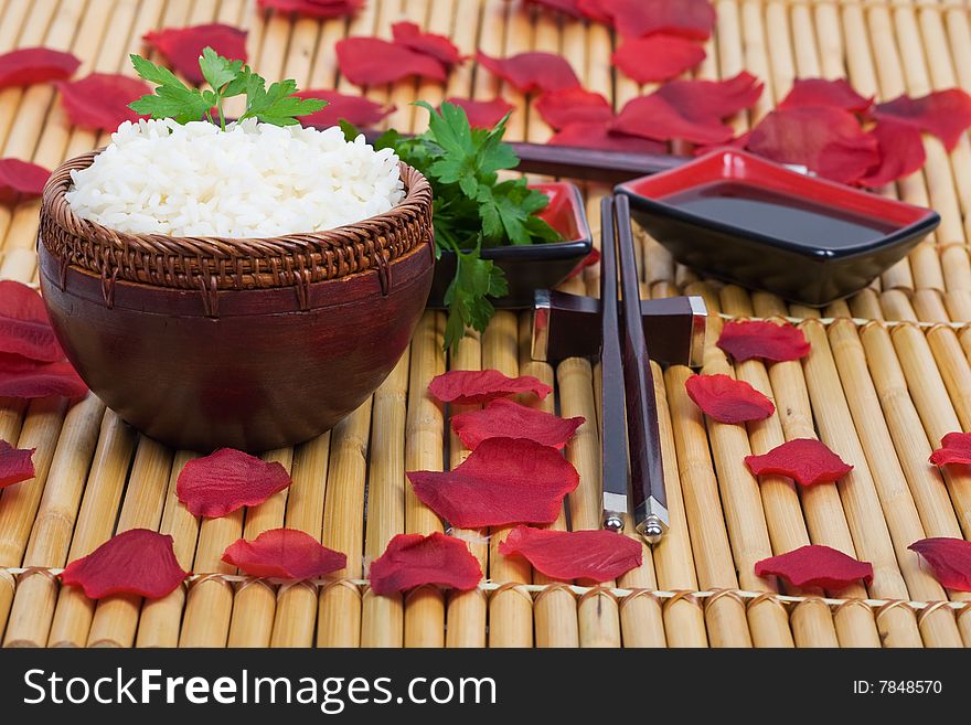 Wood rice bowl and chopsticks on bamboo mat. Wood rice bowl and chopsticks on bamboo mat