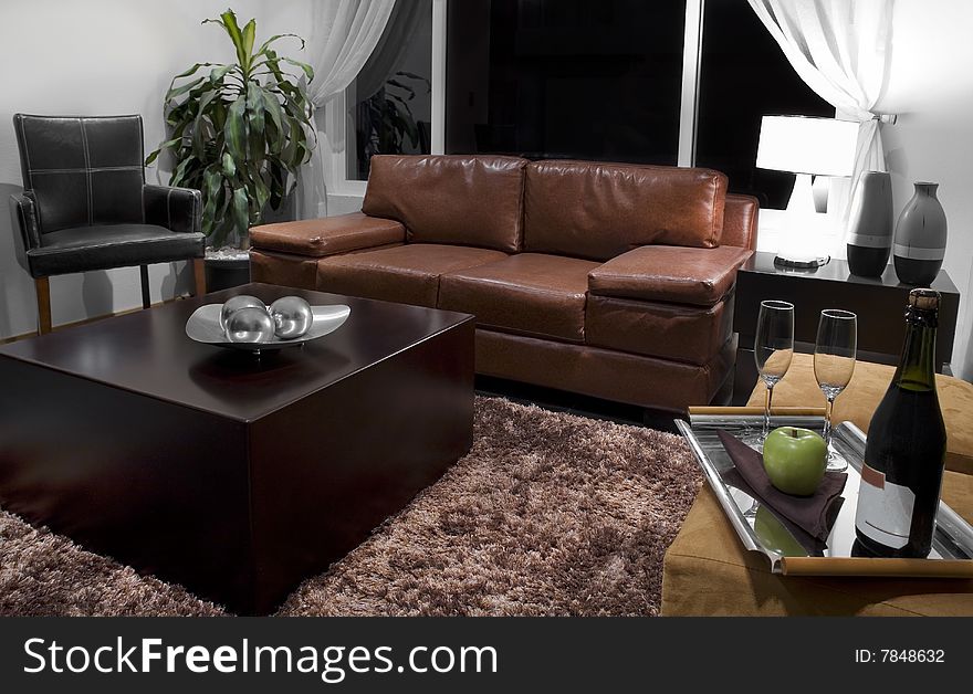 Brown sofa, leather chair, wine and wine glasses on a tray. Brown sofa, leather chair, wine and wine glasses on a tray