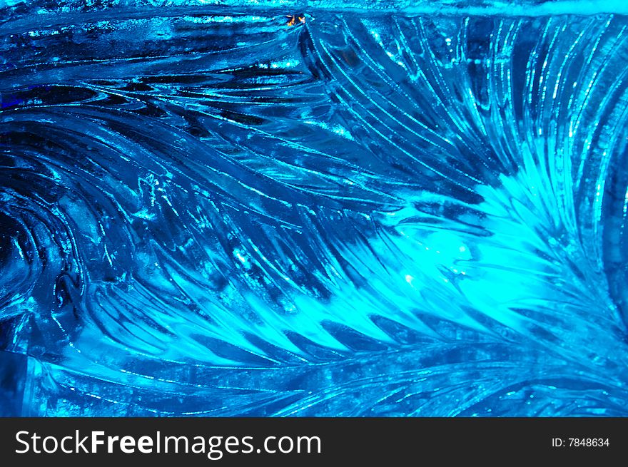 A pattern from ice is lighted up dark blue by a color.