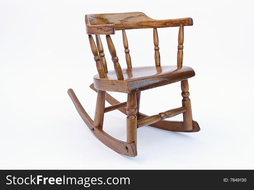 An antique children's rocking chair in finished oak wood. An antique children's rocking chair in finished oak wood