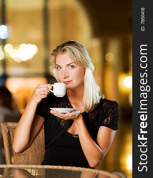 Beautiful young woman drinking coffee in a restaurant