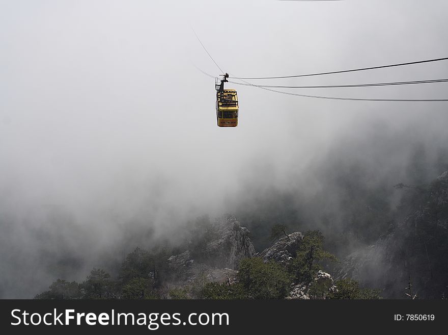 The rope-way car is shown from a cloud. Crimea, Ukraine. The rope-way car is shown from a cloud. Crimea, Ukraine