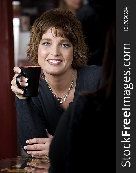 Pretty adult woman with friend in a coffee house. Pretty adult woman with friend in a coffee house