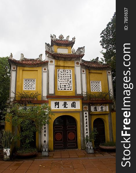 A grand entrance to a Chinese temple in Hanoi.  The temples in Hanoi, use a beautiful mustard yellow color and are usually simply decorated. A grand entrance to a Chinese temple in Hanoi.  The temples in Hanoi, use a beautiful mustard yellow color and are usually simply decorated.