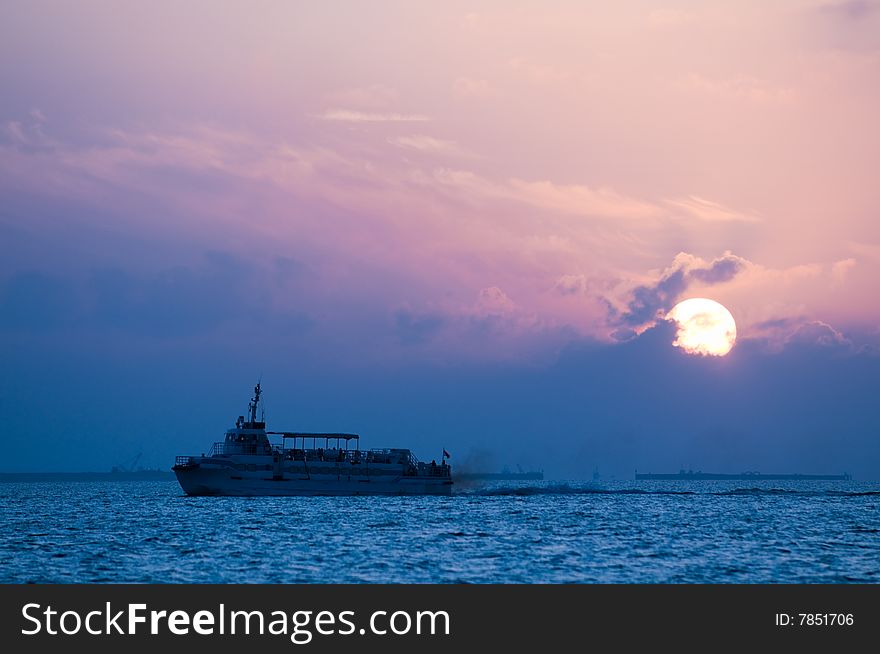 Ferry's passage even as the sun rises behind low cloud cover. Ferry's passage even as the sun rises behind low cloud cover