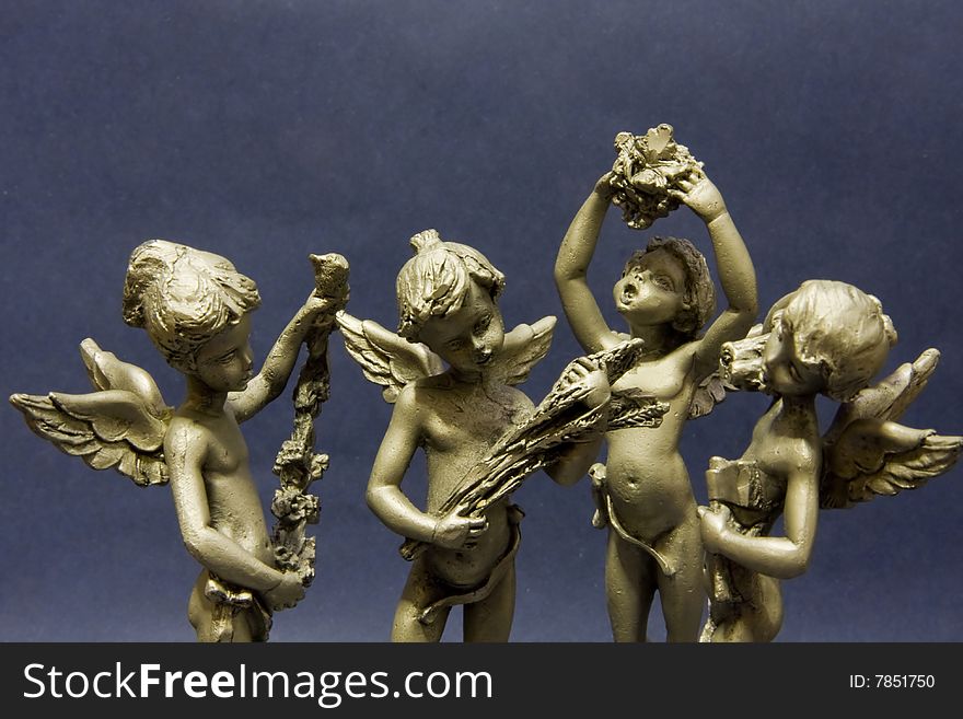 Small pewter statues representing the four seasons isolated on black background