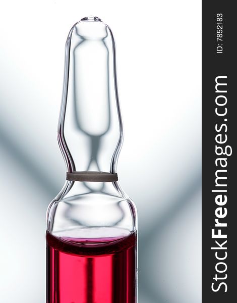 Glass ampoule with red liquid medicine