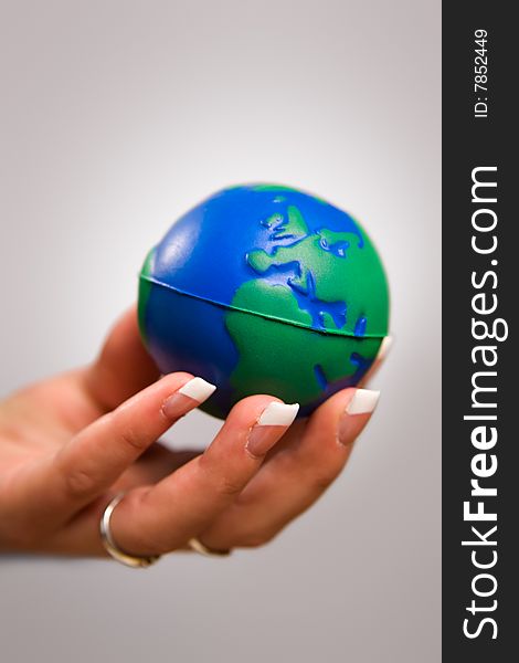 Woman's hand holding toy globe. Woman's hand holding toy globe