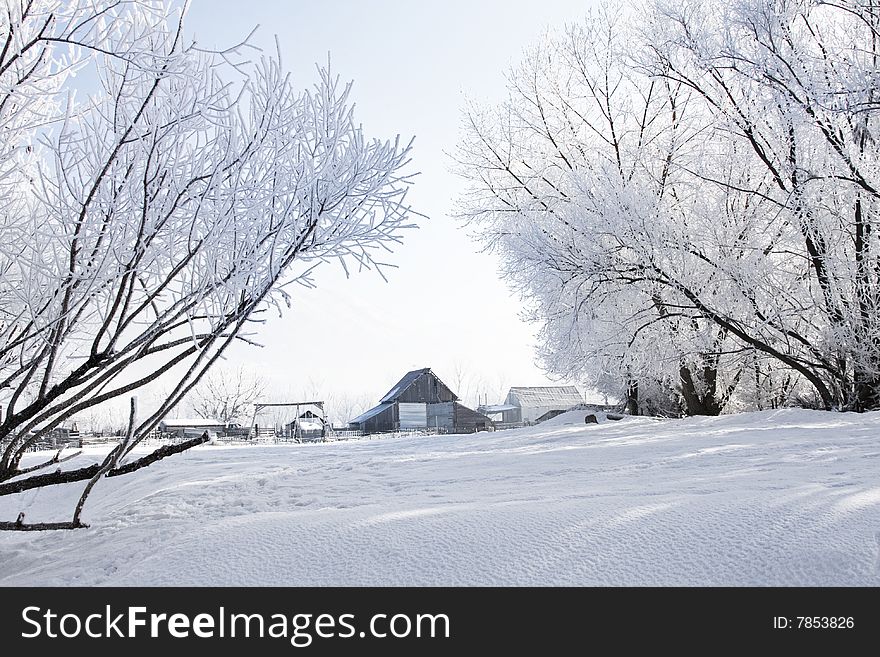 A rural barn and farmland is totally covered in beautiful white snow. A rural barn and farmland is totally covered in beautiful white snow