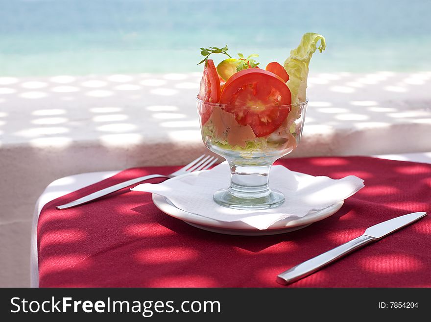 Salad in a bowl; restaurant in outdoors with sea view