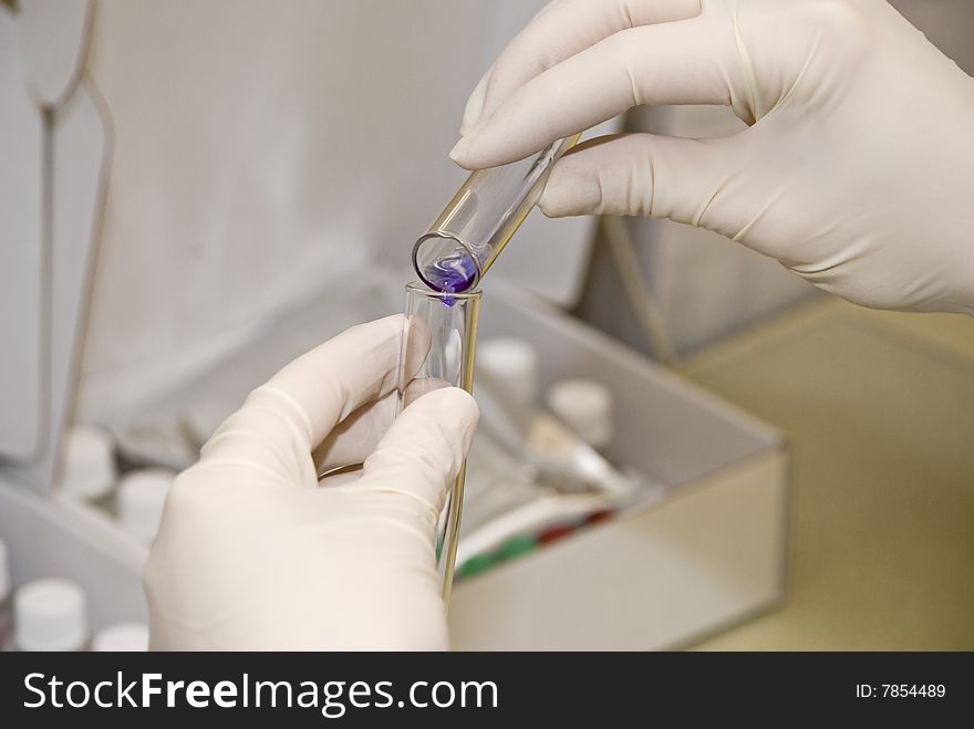 Scientist fingers holding a glass test tube in a research lab. Scientist fingers holding a glass test tube in a research lab