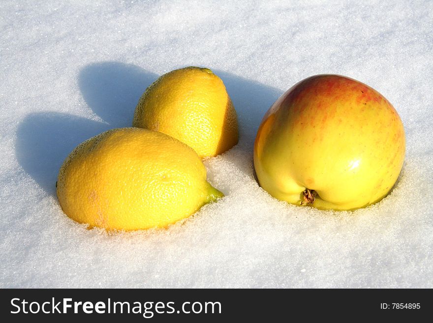 Lemons and apple lays on snow background. Lemons and apple lays on snow background.