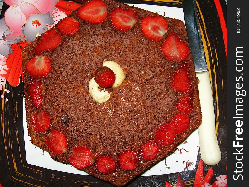 A background of delicious mouth watering cake decorated wit strawberries and crushed chocolate. A background of delicious mouth watering cake decorated wit strawberries and crushed chocolate