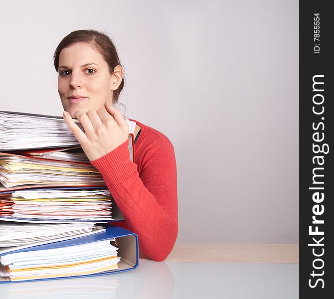 A young woman in front of a stack of paperwork. A lot of copyspace. A young woman in front of a stack of paperwork. A lot of copyspace.