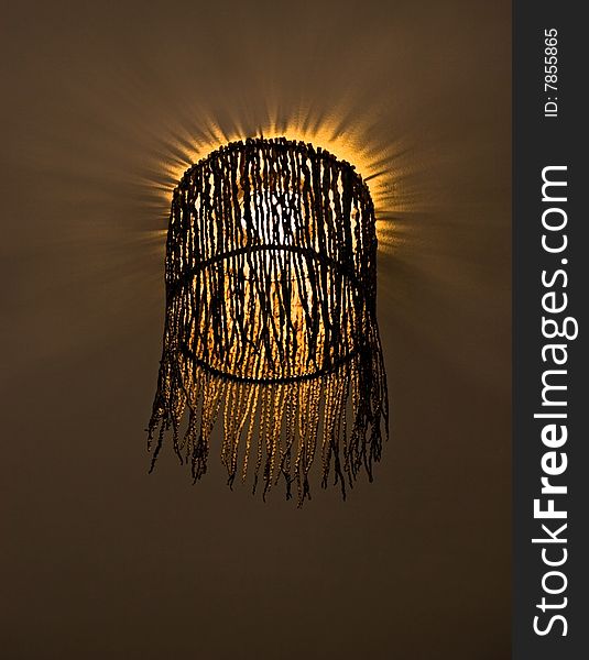 Interesting lampshade woven from twigs with shining light-bulb. Interesting lampshade woven from twigs with shining light-bulb