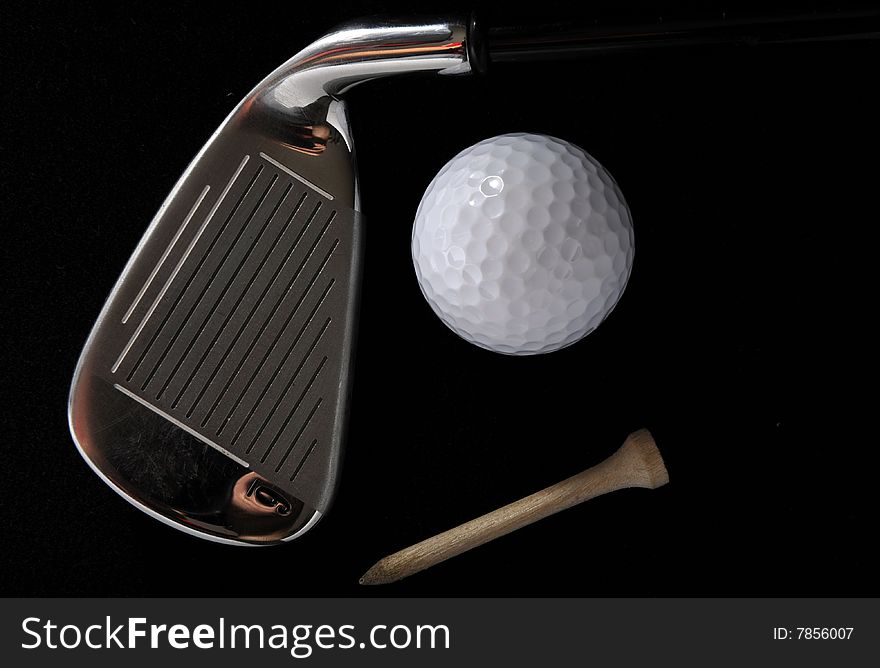 Golf club with ball and tee in the black background