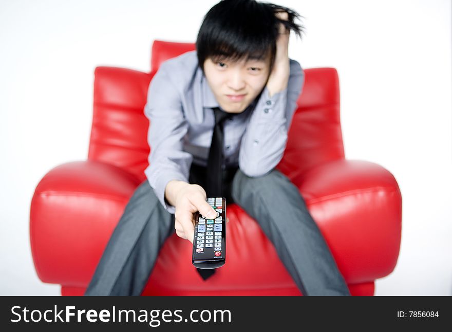 The young man in a grey shirt watches TV