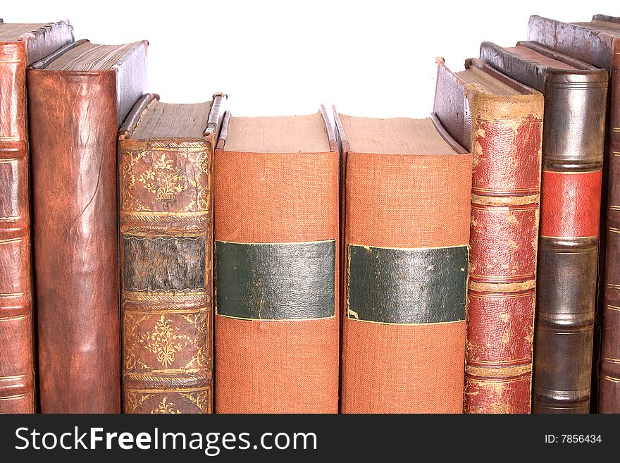 A row of old leather bound books isolated on a white background