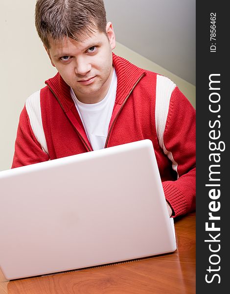 Young man working with a white laptop computer. Young man working with a white laptop computer