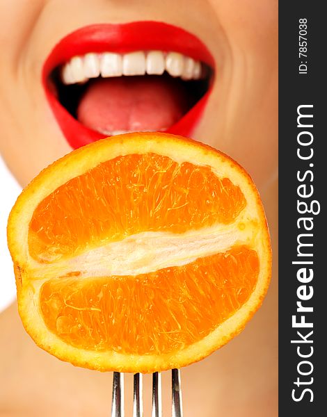 Smiling woman with orange on the fork