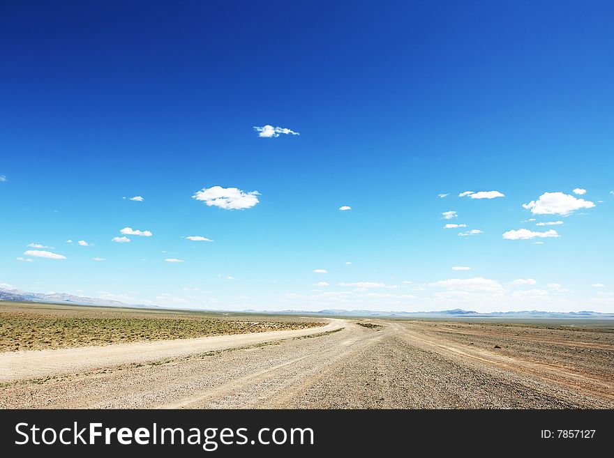 Desert road  in Mongolia with dramatic sky. Desert road  in Mongolia with dramatic sky