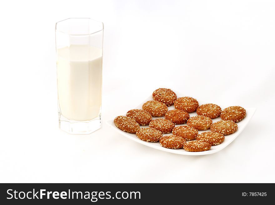 A glass of milk and a plate of cookies with white background. A glass of milk and a plate of cookies with white background