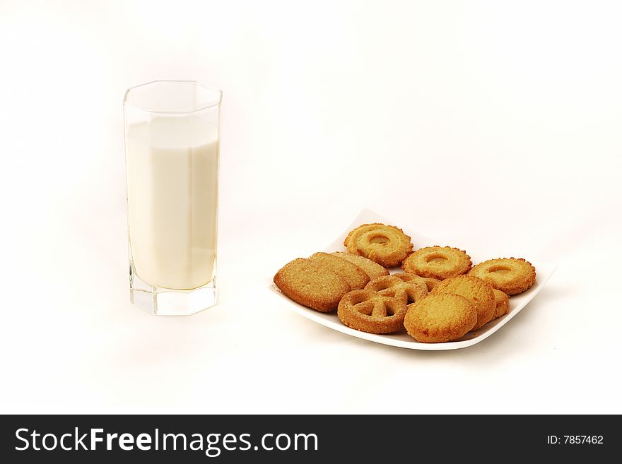 A glass of milk and a plate of cookies with white background. A glass of milk and a plate of cookies with white background