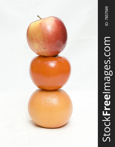 Apple, tomato and orange on the white not isolated background