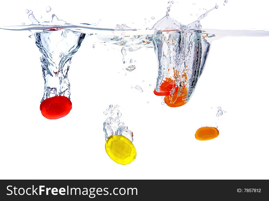 Colored sugarplums falling into the water,white background