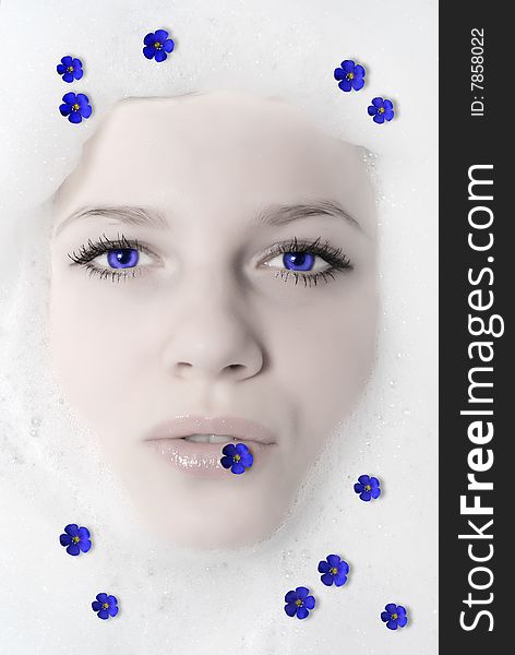 Face of a beautiful woman in white foam with violet. Face of a beautiful woman in white foam with violet