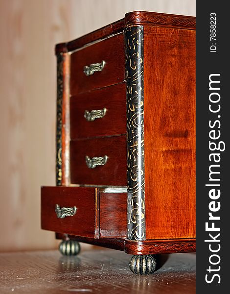 Old antique wood chest of drawers at the wall