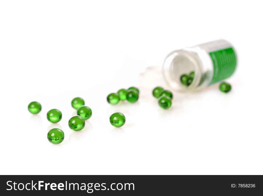 Green gel pills spilled on white surface