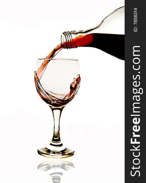 Pouring red wine in glass isolated on white