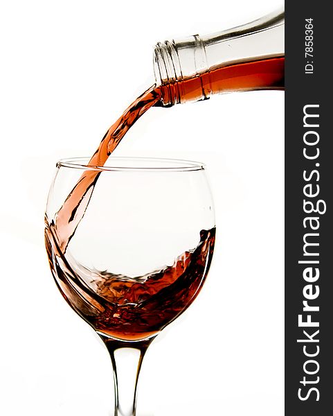 Pouring red wine in glass isolated on white