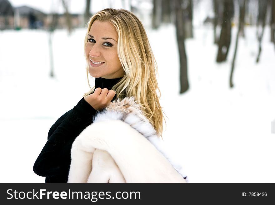 Blond girl wearing white fur coat in winter. Blond girl wearing white fur coat in winter