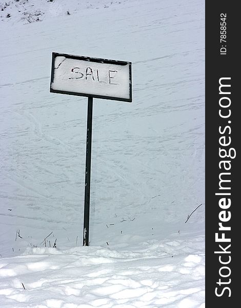 Sale sign standing on the snow