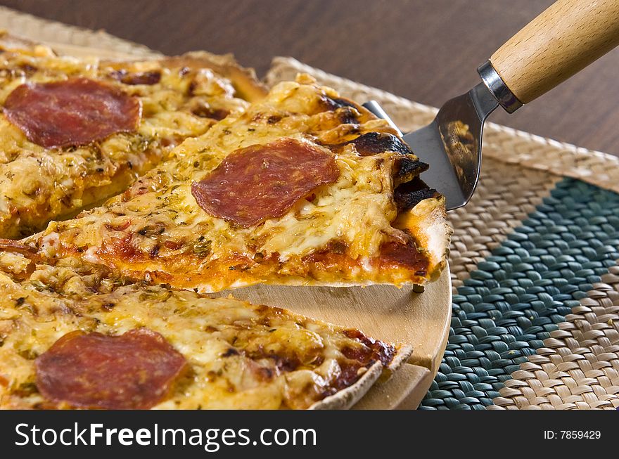 Peperoni pizza served on wooden board