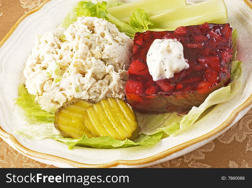 Chicken salad plate with cranberry salad topped with poppy seed dressing