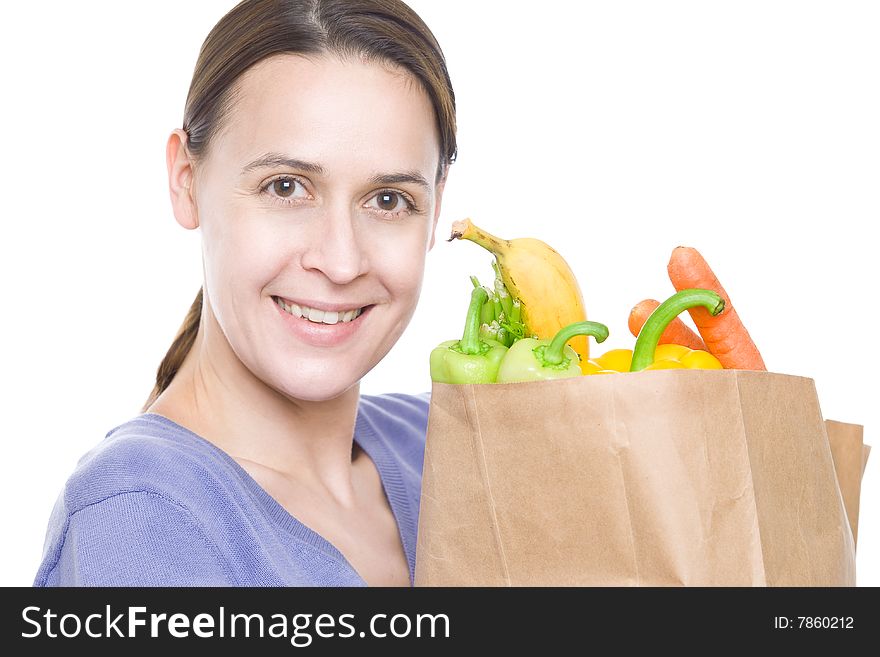A smiling woman in a household role with fresh groceries on a white background. A smiling woman in a household role with fresh groceries on a white background