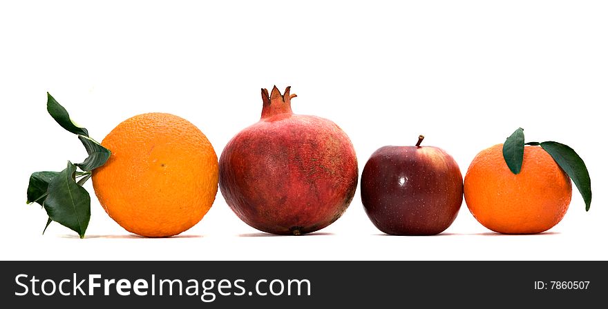 Pomegranate, orange, tangerine, and apple isolated on white background