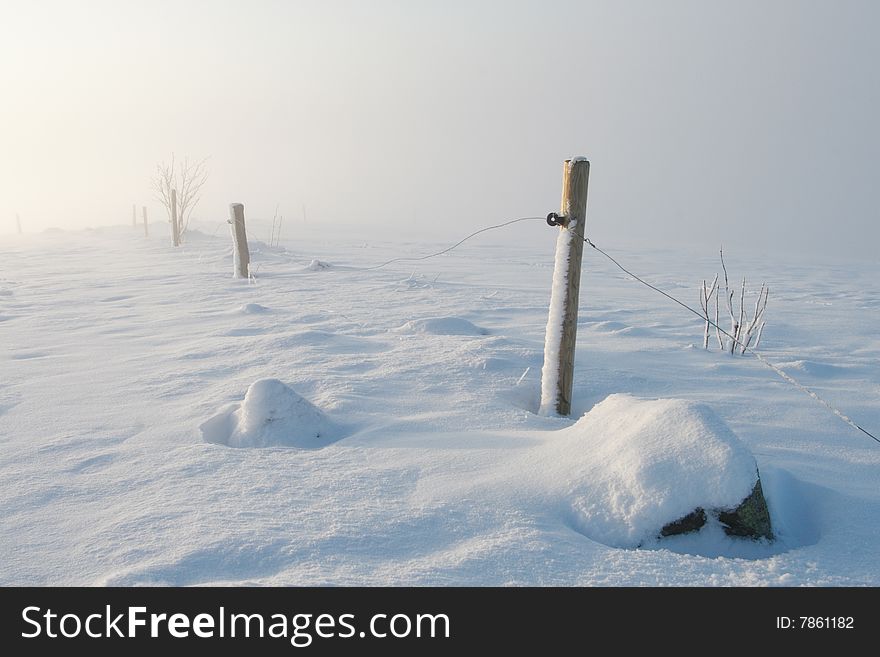 Sun in the fog and picket at snow