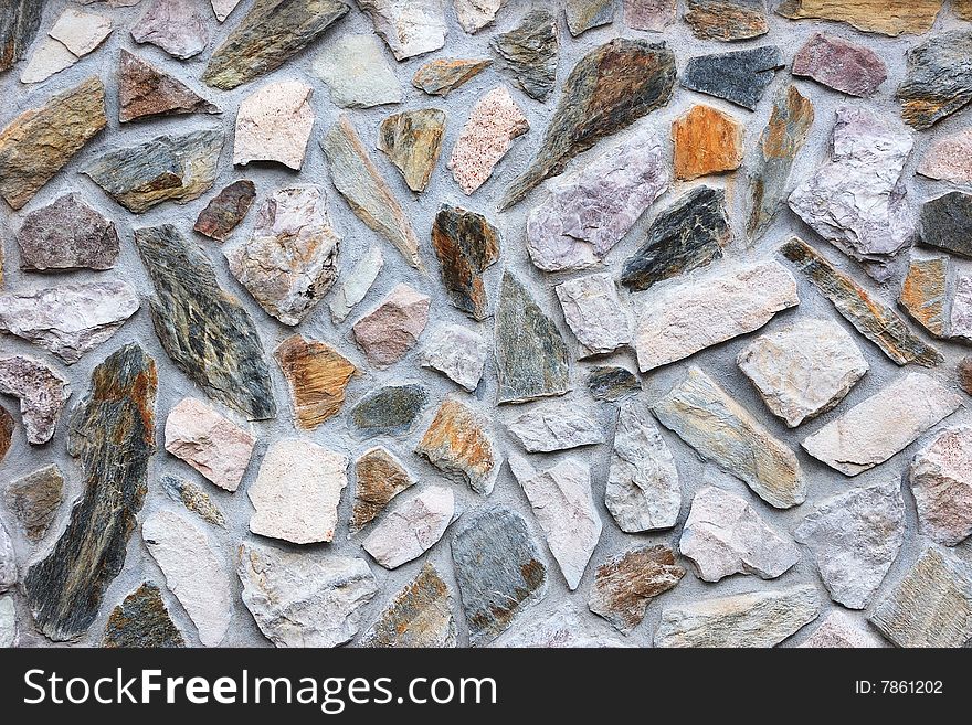 Fragment of rough colored stone wall. Fragment of rough colored stone wall