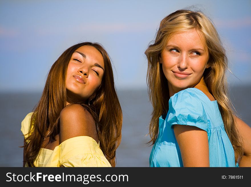 Two young girls playful on a beach. Two young girls playful on a beach
