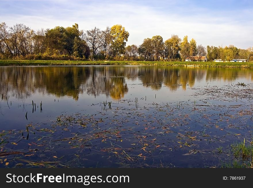 His lake aqua reflect autumnal trees.