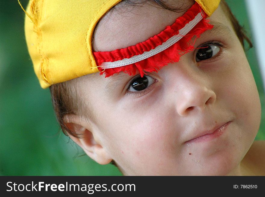 Child of two years with black eyes and yellow cap. Child of two years with black eyes and yellow cap