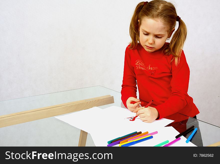 Young girl in red drawing an image. Isolated. Young girl in red drawing an image. Isolated.